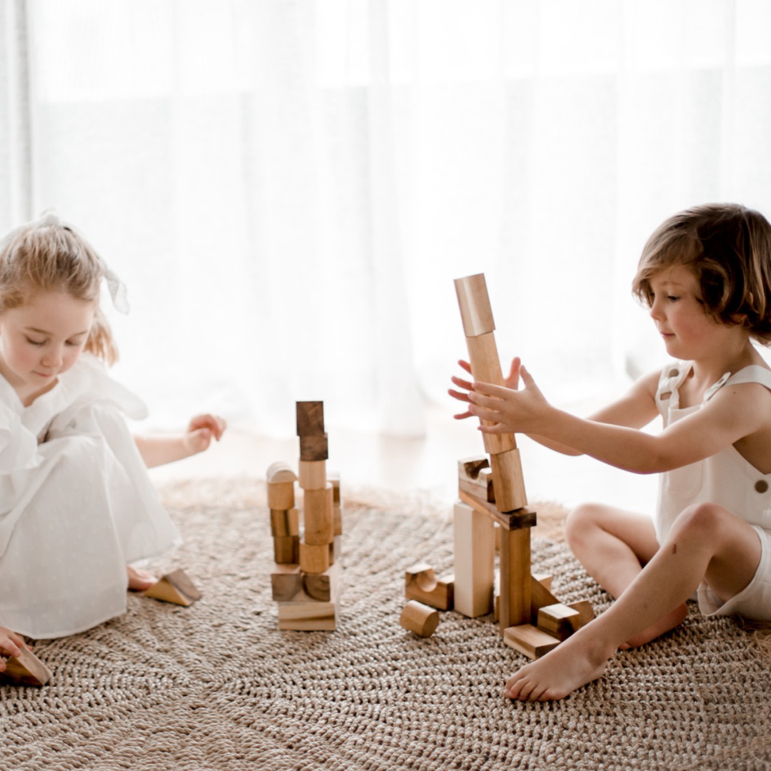 Children building towers with the wooden building blocks of the Project Blocks 117 piece set from QToys